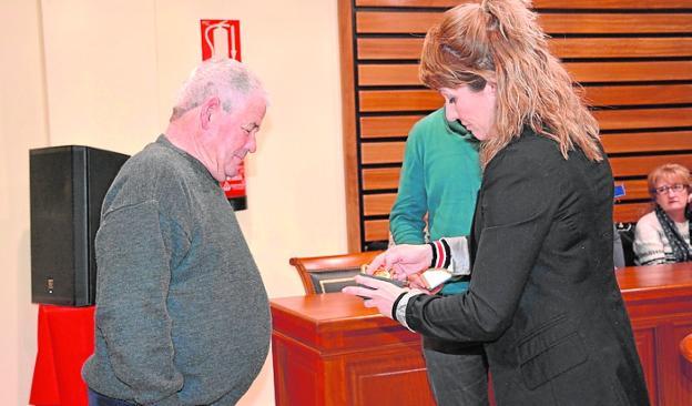 La alcaldesa entrega la medalla a uno de los familiares. 