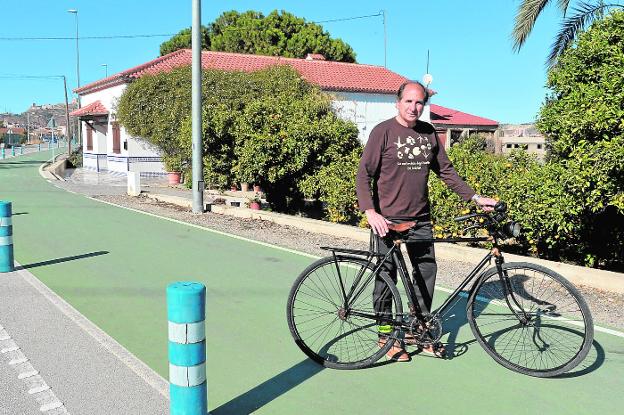 Manuel Martín con su bicicleta en el carril bici de Cazalla que transcurre entre naranjos, como se puede apreciar en la foto. 