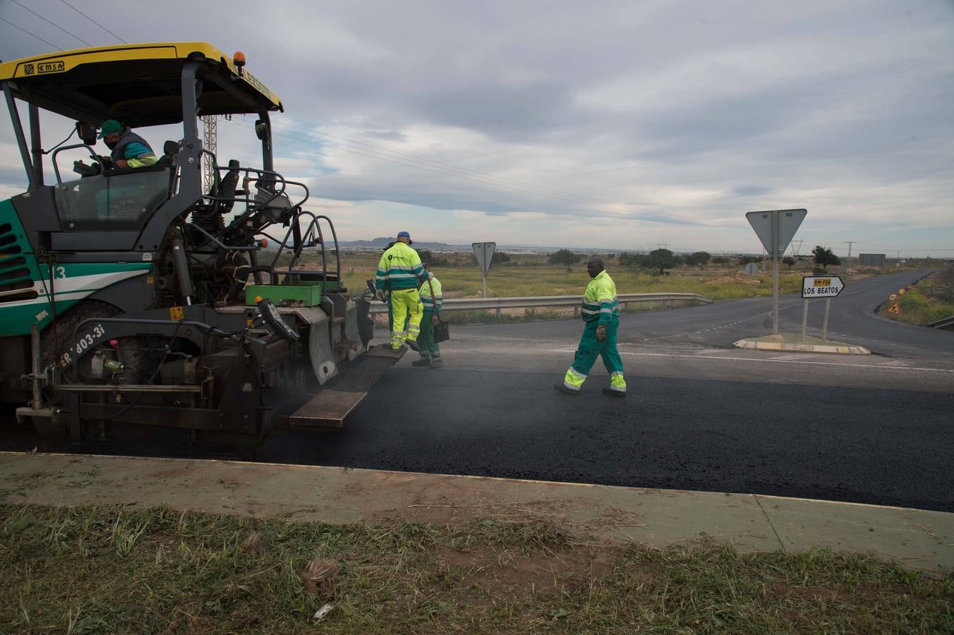 Un grupo de operarios asfalta la rotonda de acceso al polígono industrial Los Camachos, después de hacer lo mismo con la carretera RM-F39, lateral a la futura ZAL.