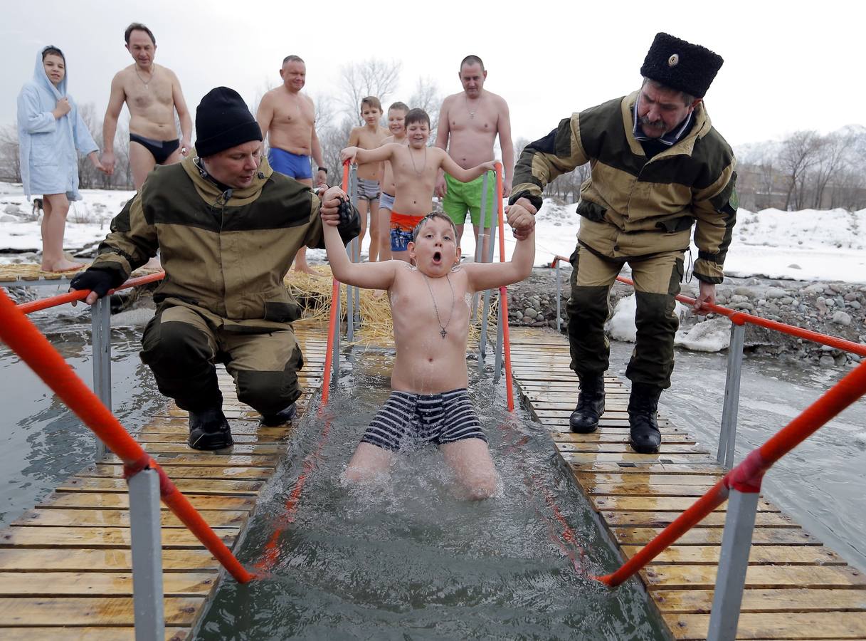 Varias personas se dan un baño en las aguas heladas de un lago para celebrar la Epifanía, cerca de la localidad de Vorontsovka, Biskek (Kirguistán). Los fieles creen que darse un chapuzón en aguas bendecidas fortalece cuerpo y espíritu.