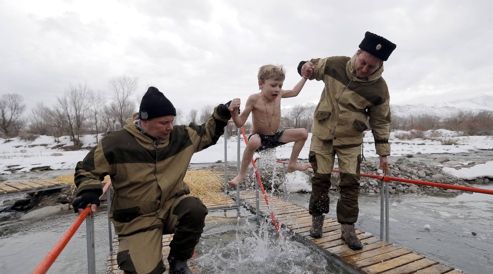 Varias personas se dan un baño en las aguas heladas de un lago para celebrar la Epifanía, cerca de la localidad de Vorontsovka, Biskek (Kirguistán). Los fieles creen que darse un chapuzón en aguas bendecidas fortalece cuerpo y espíritu.