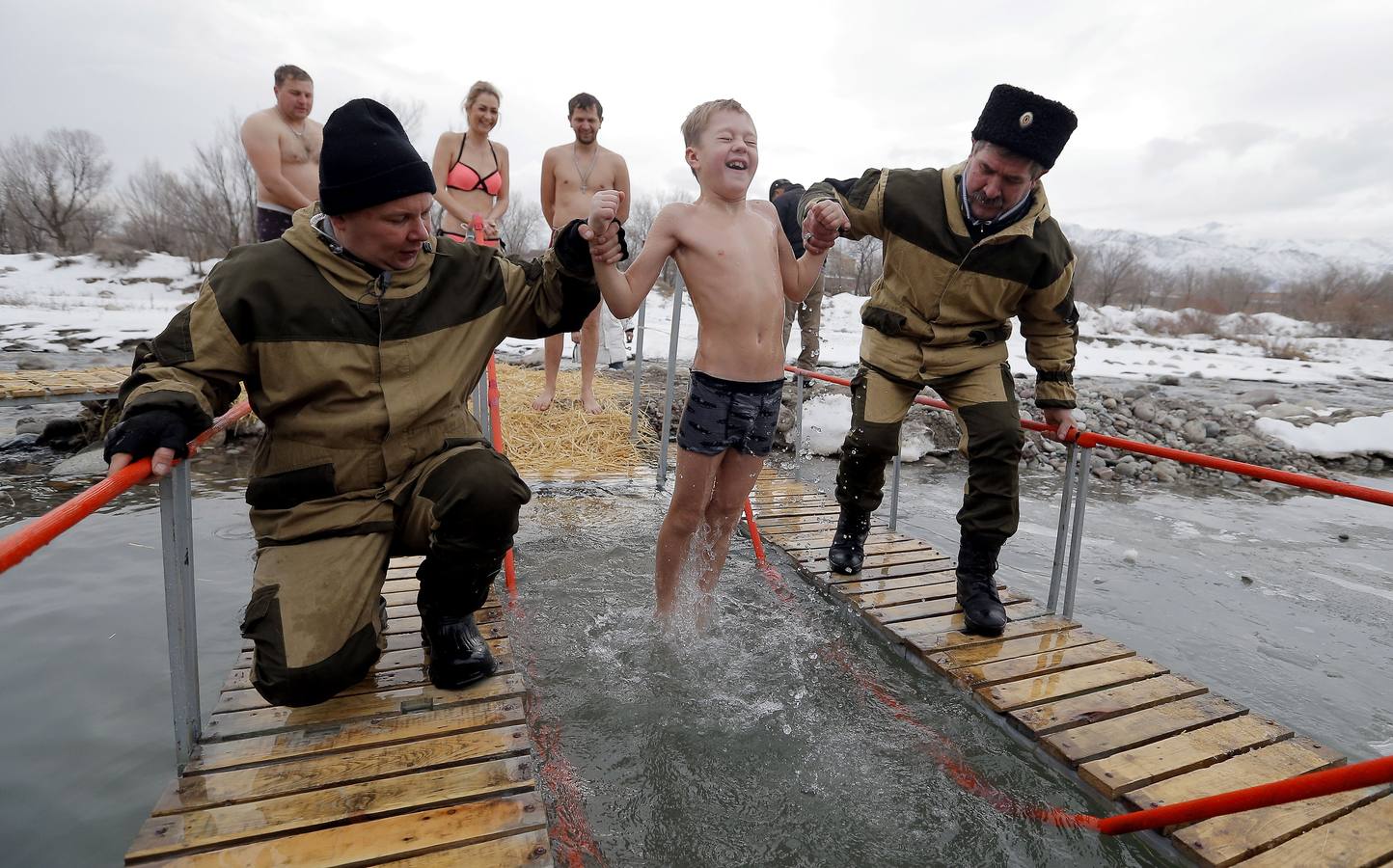 Varias personas se dan un baño en las aguas heladas de un lago para celebrar la Epifanía, cerca de la localidad de Vorontsovka, Biskek (Kirguistán). Los fieles creen que darse un chapuzón en aguas bendecidas fortalece cuerpo y espíritu.