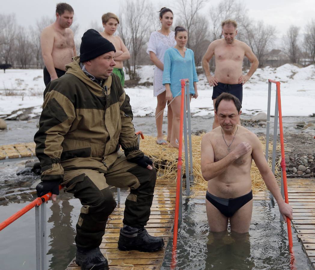 Varias personas se dan un baño en las aguas heladas de un lago para celebrar la Epifanía, cerca de la localidad de Vorontsovka, Biskek (Kirguistán). Los fieles creen que darse un chapuzón en aguas bendecidas fortalece cuerpo y espíritu.