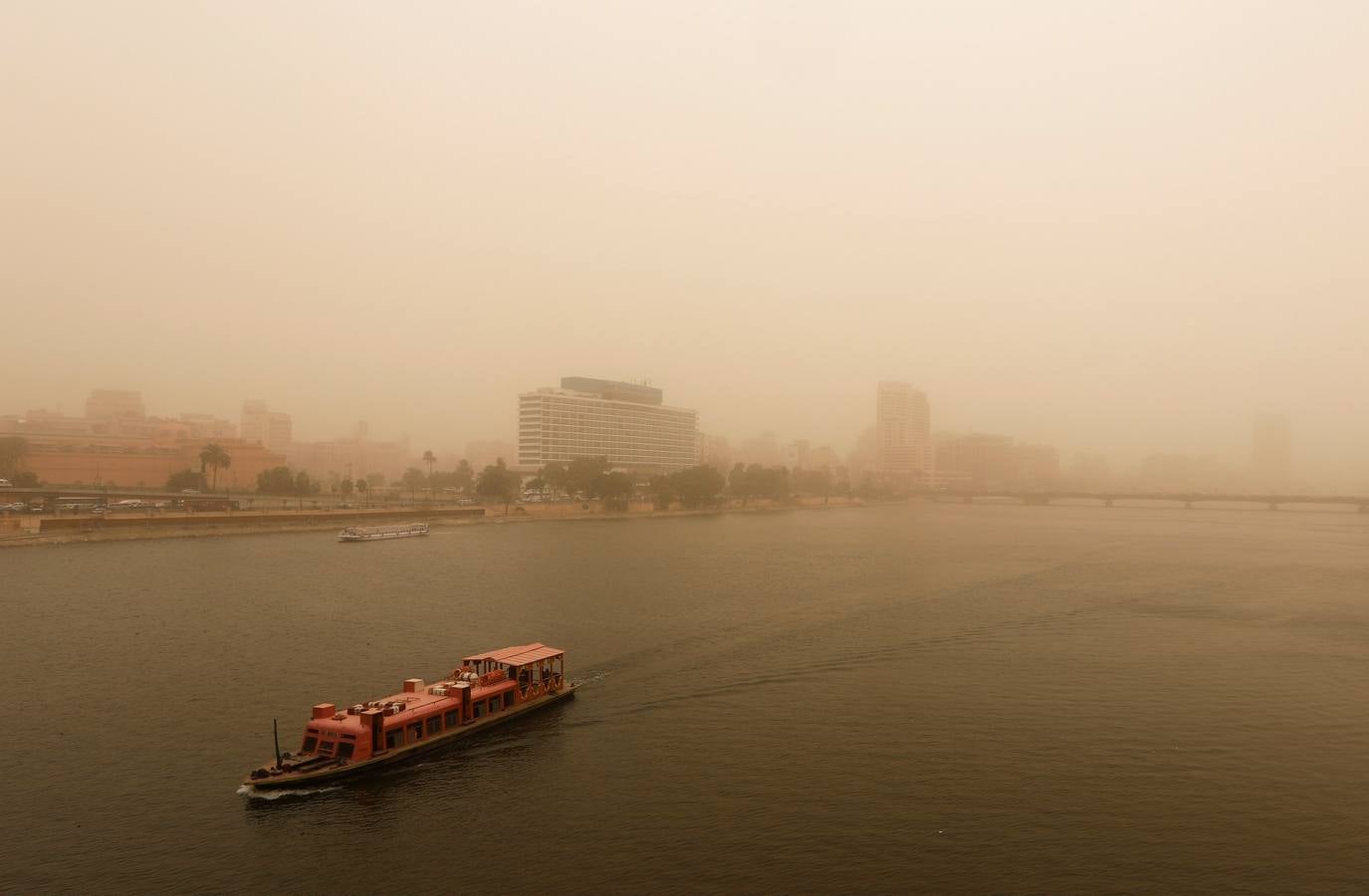 Varias personas se cubren el rostro durante una tormenta de arena en El Cairo, Egipto. La tormenta provocó que varios zoos y parques tuvieran que cerrar sus puertas al público.