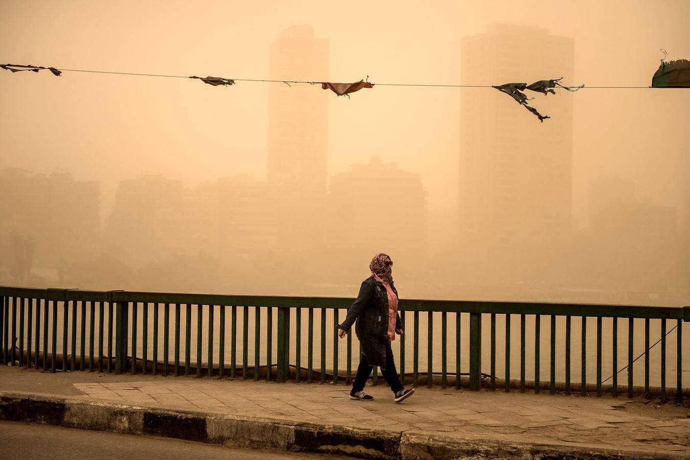 Varias personas se cubren el rostro durante una tormenta de arena en El Cairo, Egipto. La tormenta provocó que varios zoos y parques tuvieran que cerrar sus puertas al público.