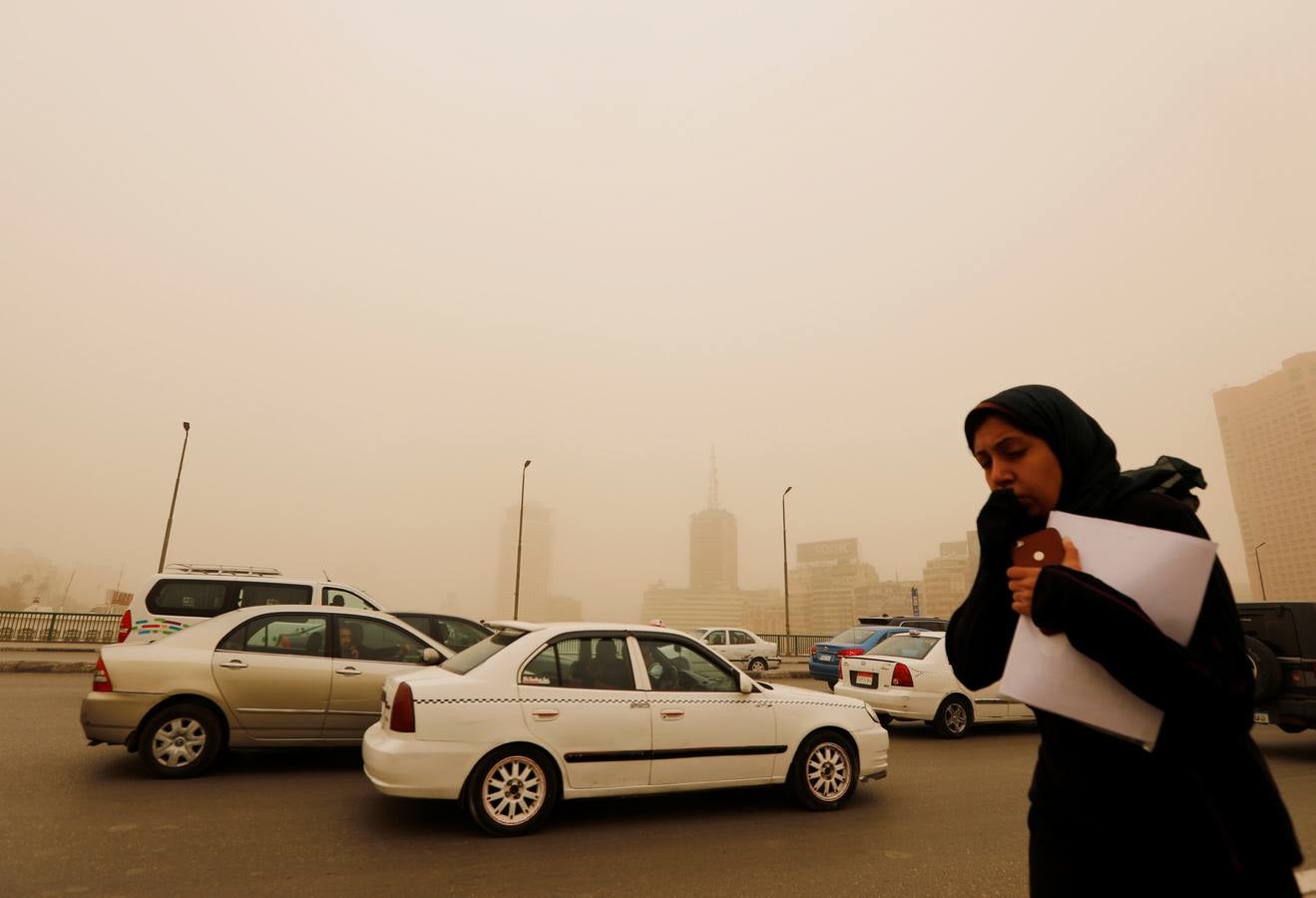 Varias personas se cubren el rostro durante una tormenta de arena en El Cairo, Egipto. La tormenta provocó que varios zoos y parques tuvieran que cerrar sus puertas al público.