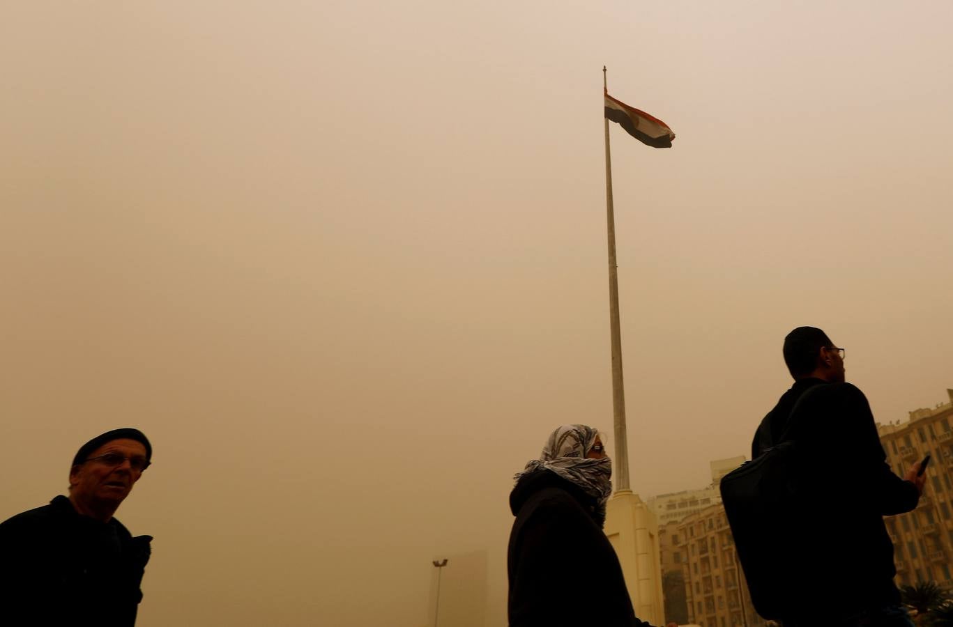 Varias personas se cubren el rostro durante una tormenta de arena en El Cairo, Egipto. La tormenta provocó que varios zoos y parques tuvieran que cerrar sus puertas al público.