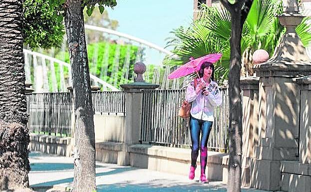 Una mujer se protege del intenso calor con un parasol en el centro de Murcia en una foto de archivo.