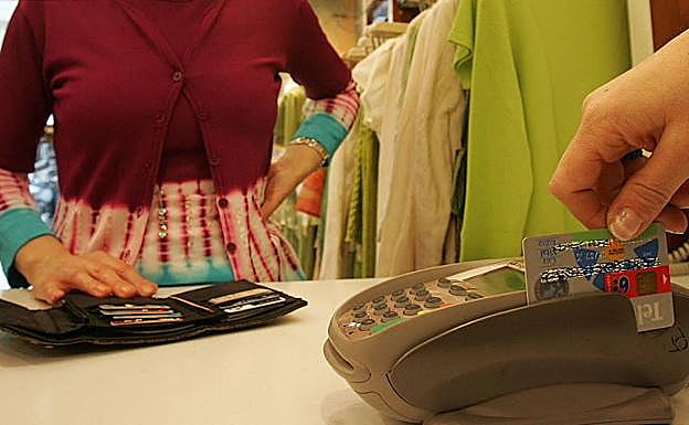 Un cliente usa su tarjeta de crédito para pagar en un comercio.