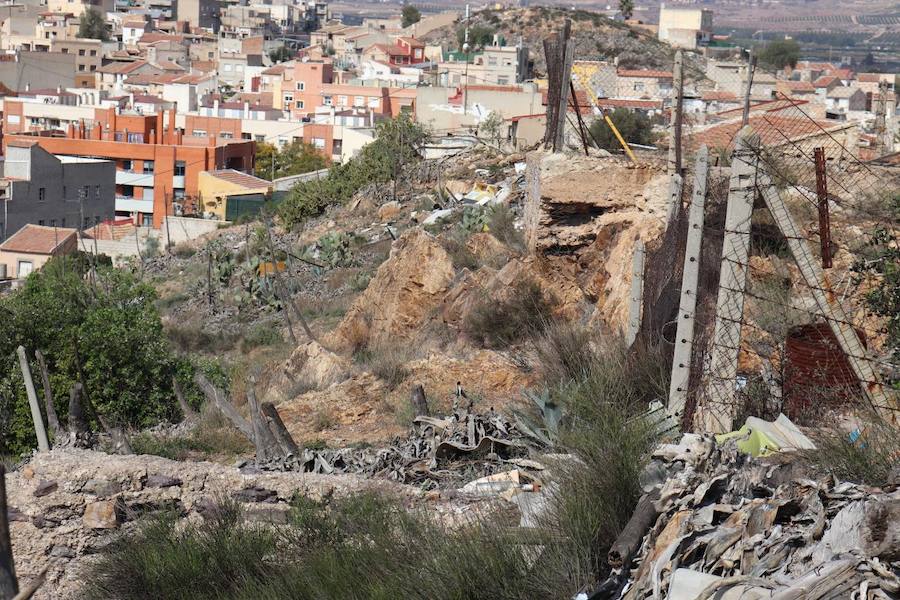 La organización advierte de la «situación alarmante» de estos edificios, ya que parte de sus muros sufren desprendimientos y desperfectos, tienen zonas cubiertas de escombros y basuras y están anegados de maleza