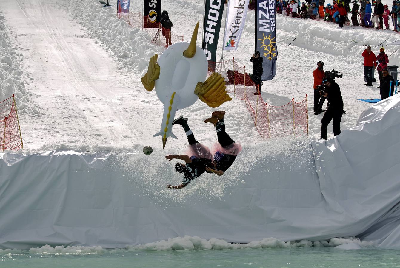 Varios participantes participan en competención Red Bull Jump and Freeze en la estación de esquí Mzaar en Kfardebian Lebanon Mountain, en Kfardebian, Líbano. Los participantes que usan trajes festivos realizan piruetas antes de meterse en un estanque con agua helada. 