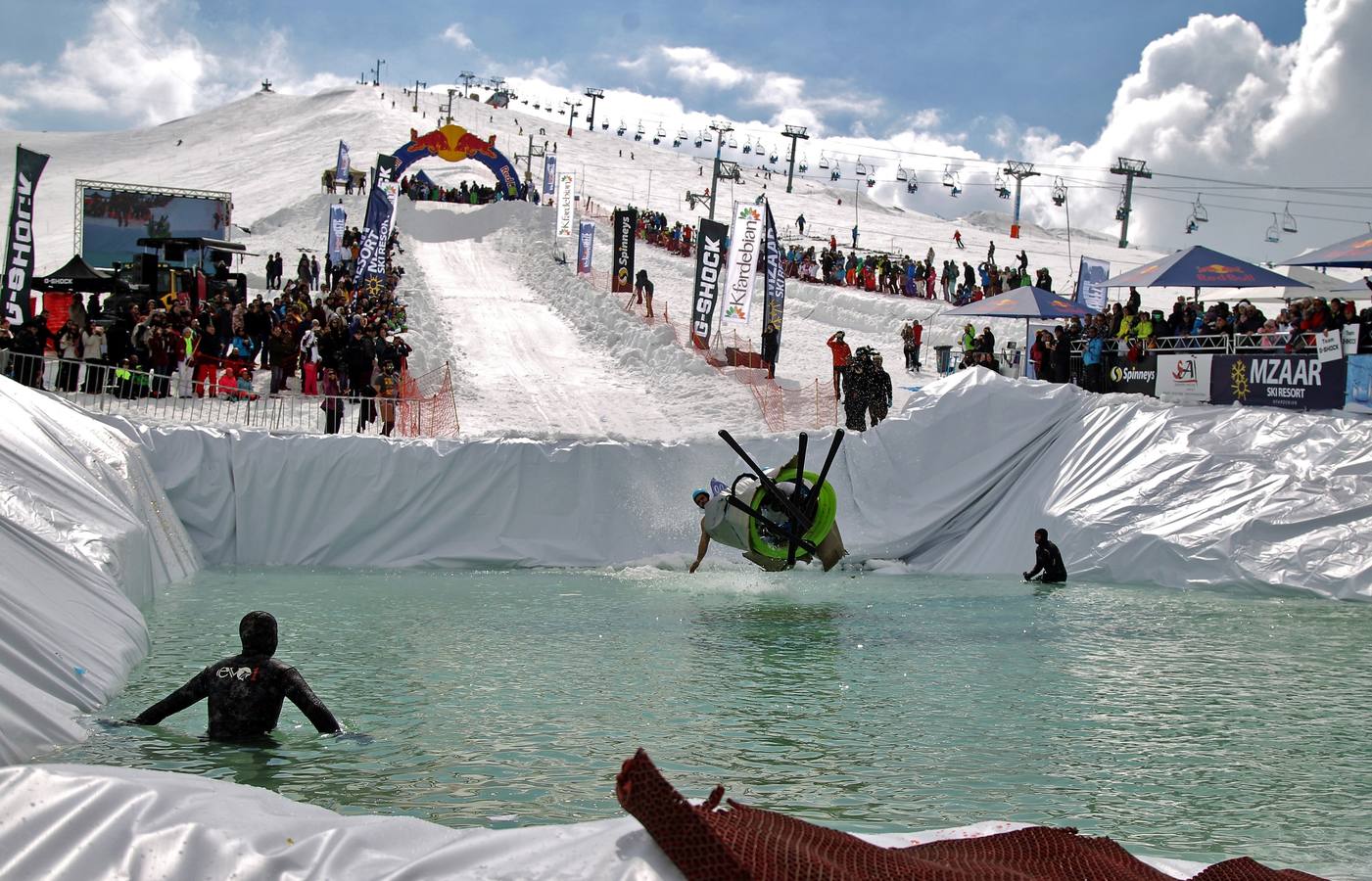 Varios participantes participan en competención Red Bull Jump and Freeze en la estación de esquí Mzaar en Kfardebian Lebanon Mountain, en Kfardebian, Líbano. Los participantes que usan trajes festivos realizan piruetas antes de meterse en un estanque con agua helada. 