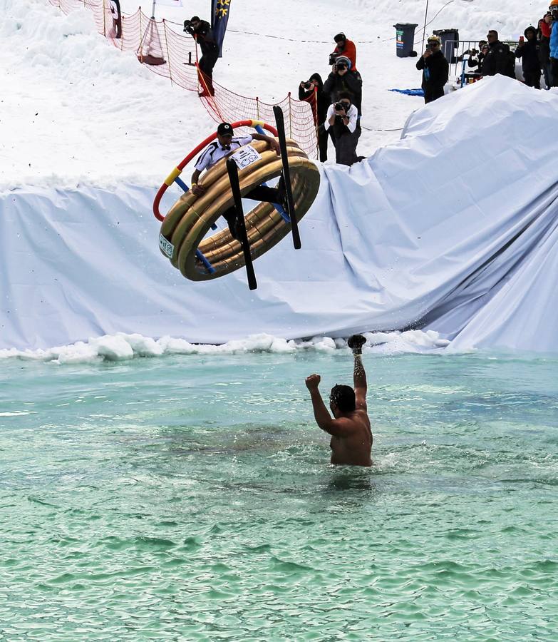 Varios participantes participan en competención Red Bull Jump and Freeze en la estación de esquí Mzaar en Kfardebian Lebanon Mountain, en Kfardebian, Líbano. Los participantes que usan trajes festivos realizan piruetas antes de meterse en un estanque con agua helada. 