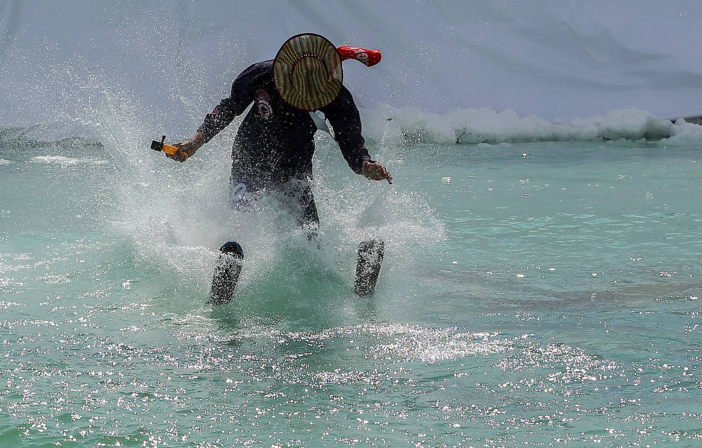 Varios participantes participan en competención Red Bull Jump and Freeze en la estación de esquí Mzaar en Kfardebian Lebanon Mountain, en Kfardebian, Líbano. Los participantes que usan trajes festivos realizan piruetas antes de meterse en un estanque con agua helada. 