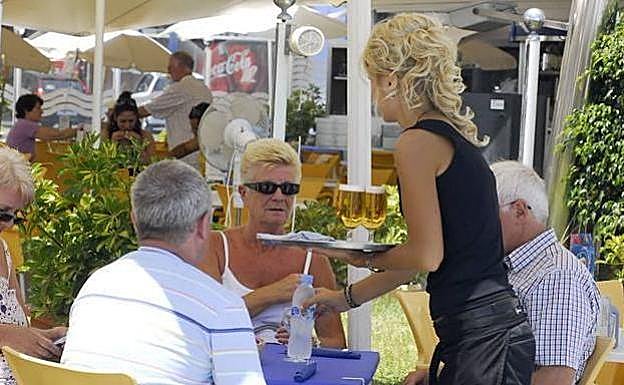 Una camarera atiende a unos clientes.