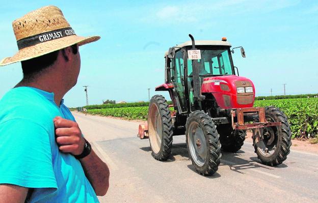 Un agricultor ve pasar a un tractor por un camino asfaltado del trasvase, en una foto de archivo. 