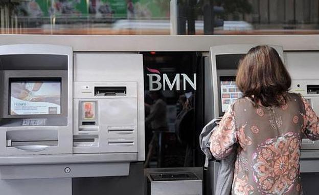 Una mujer consulta un cajero.