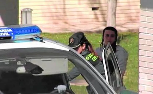 Un guardia civil conduce al coche policial a la madre de los niños. 