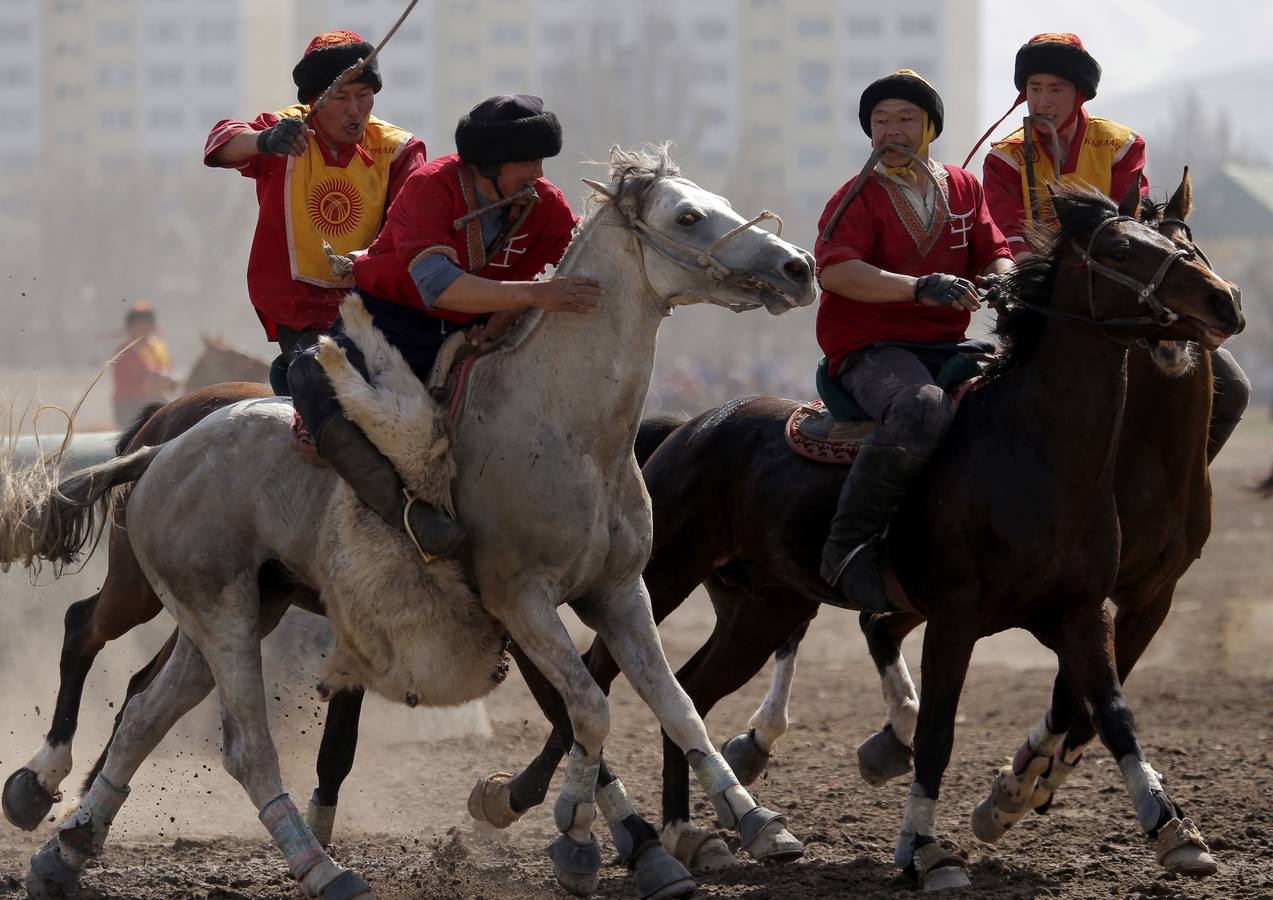 Varios jinetes participan en la competición tradicional kirguizistana llamada 'Kok-Boru', o arrastre de la cabra, con motivo de las celebraciones del Año Nuevo en el calendario solar persa, en Biskek (Kirguizistán). En el Kok-Boru los jugadores deben agarrar el cuerpo de una cabra desde el suelo mientras montan a caballo e intentar anotar un tanto al dejarlo sobre la portería del contrario.