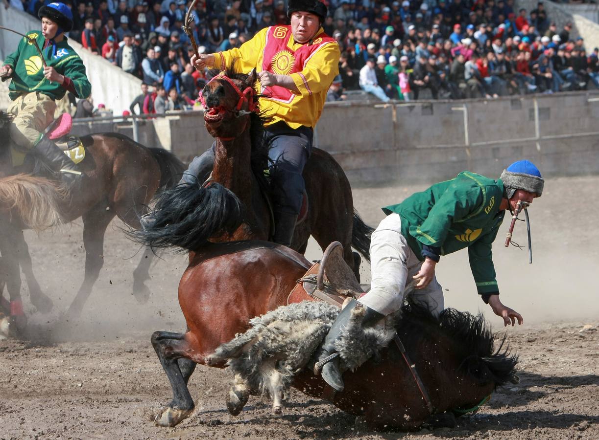Varios jinetes participan en la competición tradicional kirguizistana llamada 'Kok-Boru', o arrastre de la cabra, con motivo de las celebraciones del Año Nuevo en el calendario solar persa, en Biskek (Kirguizistán). En el Kok-Boru los jugadores deben agarrar el cuerpo de una cabra desde el suelo mientras montan a caballo e intentar anotar un tanto al dejarlo sobre la portería del contrario.