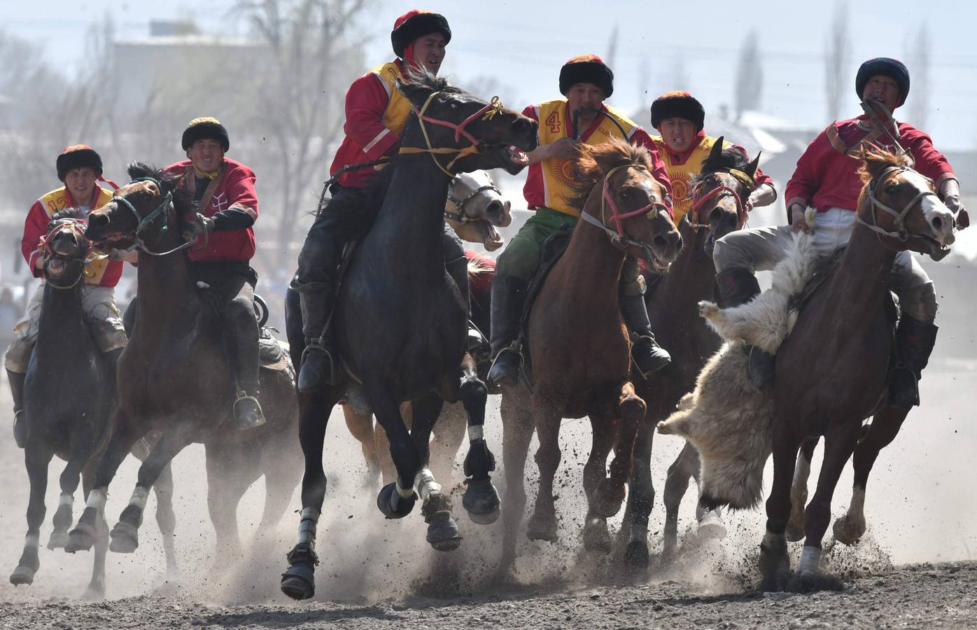 Varios jinetes participan en la competición tradicional kirguizistana llamada 'Kok-Boru', o arrastre de la cabra, con motivo de las celebraciones del Año Nuevo en el calendario solar persa, en Biskek (Kirguizistán). En el Kok-Boru los jugadores deben agarrar el cuerpo de una cabra desde el suelo mientras montan a caballo e intentar anotar un tanto al dejarlo sobre la portería del contrario.