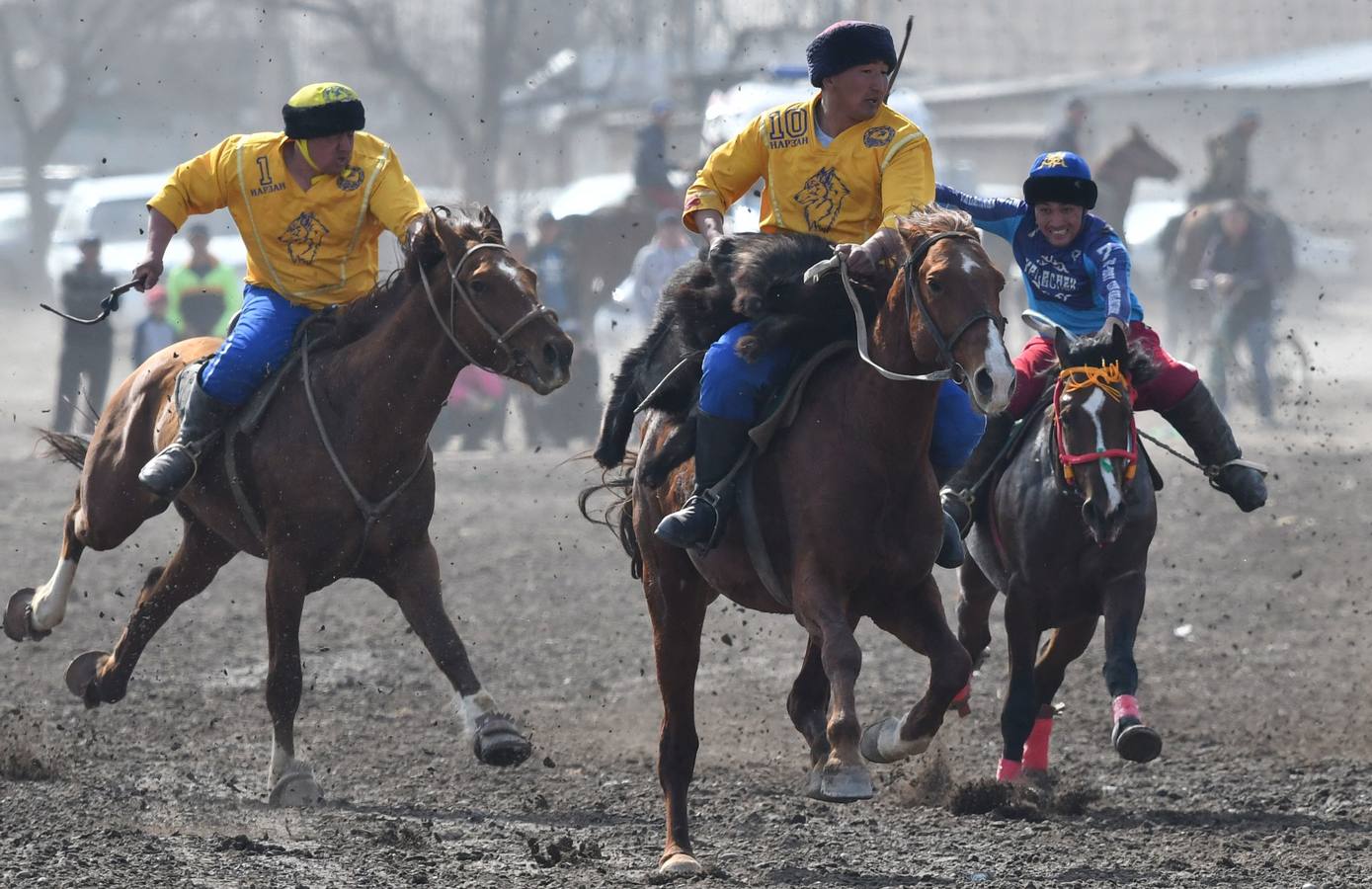 Varios jinetes participan en la competición tradicional kirguizistana llamada 'Kok-Boru', o arrastre de la cabra, con motivo de las celebraciones del Año Nuevo en el calendario solar persa, en Biskek (Kirguizistán). En el Kok-Boru los jugadores deben agarrar el cuerpo de una cabra desde el suelo mientras montan a caballo e intentar anotar un tanto al dejarlo sobre la portería del contrario.