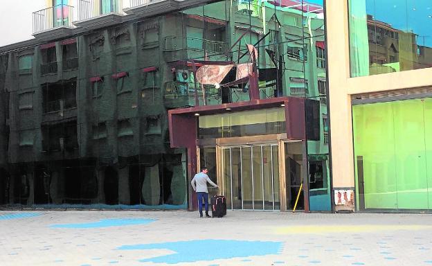 Un turista llega a un hotel en la plaza del Ayuntamiento, aún en obras, en Los Alcázares. 