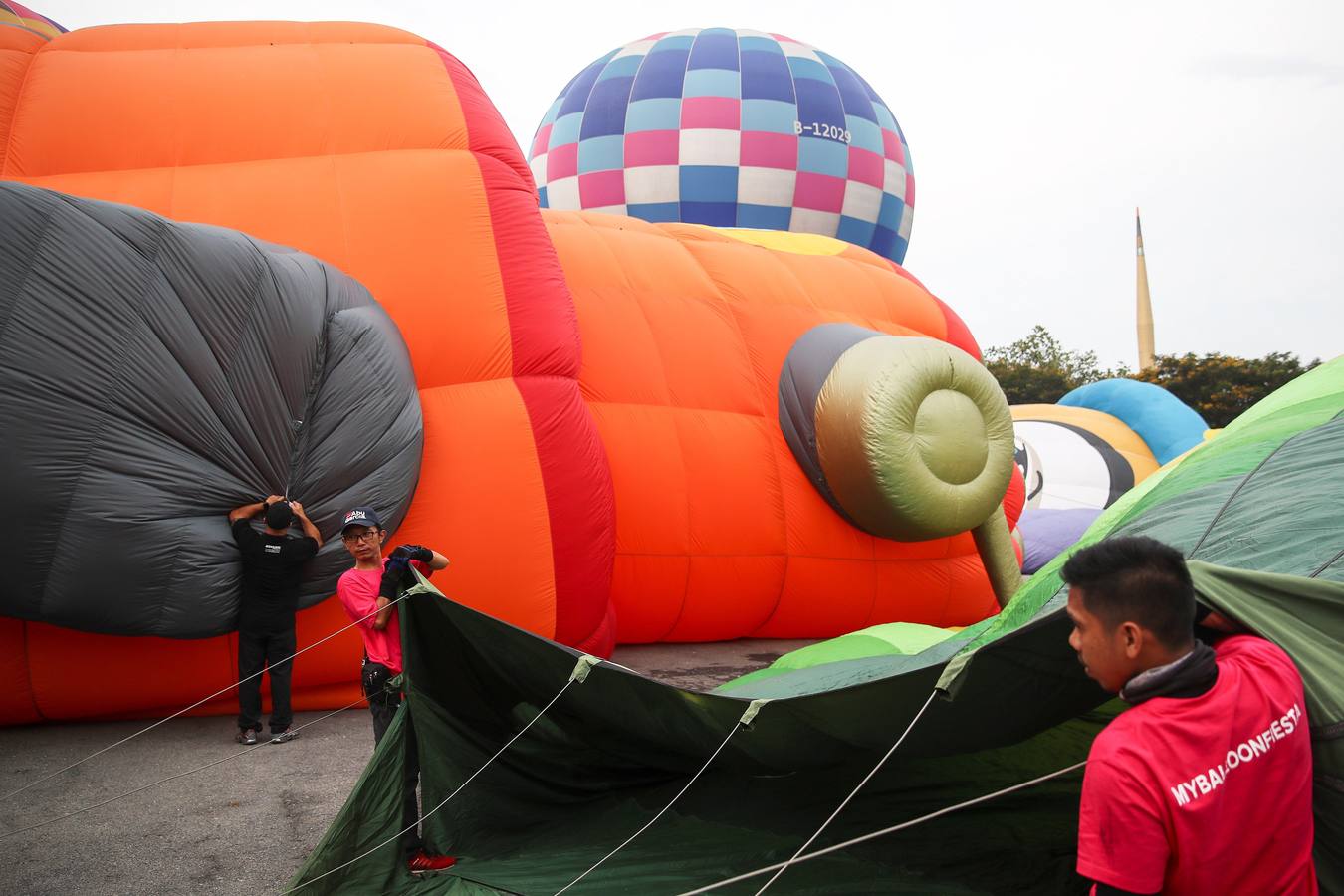 Varias personas asisten a la décima Fiesta Internacional de Globos Aerostáticos de Putrajaya (Malasia). Más de 20 globos aerostáticos volaron por los cielos en la fiesta anual, organizada para promover el turismo y los deportes de aviación. 