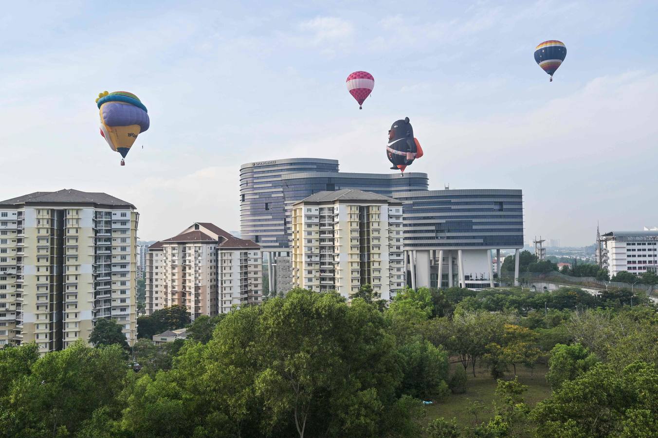 Varias personas asisten a la décima Fiesta Internacional de Globos Aerostáticos de Putrajaya (Malasia). Más de 20 globos aerostáticos volaron por los cielos en la fiesta anual, organizada para promover el turismo y los deportes de aviación. 