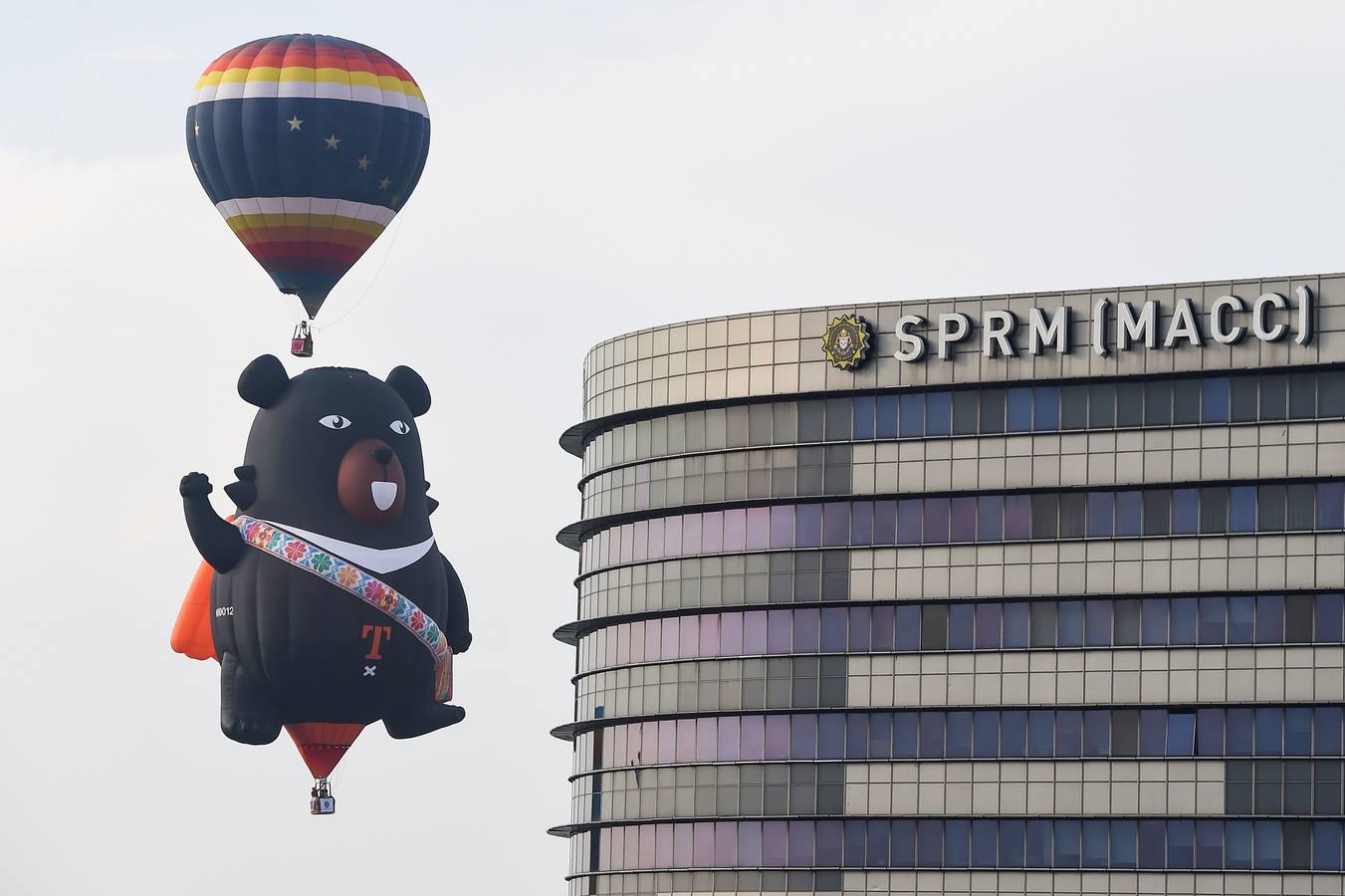 Varias personas asisten a la décima Fiesta Internacional de Globos Aerostáticos de Putrajaya (Malasia). Más de 20 globos aerostáticos volaron por los cielos en la fiesta anual, organizada para promover el turismo y los deportes de aviación. 