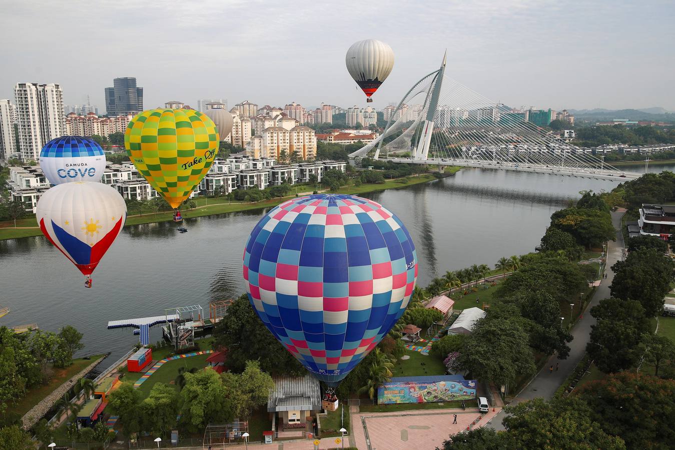 Varias personas asisten a la décima Fiesta Internacional de Globos Aerostáticos de Putrajaya (Malasia). Más de 20 globos aerostáticos volaron por los cielos en la fiesta anual, organizada para promover el turismo y los deportes de aviación. 