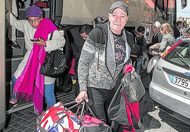 Arriba, usuarios del Altaria bajan ayer del autobús procedente de Murcia. A la izquierda, la web de Renfe, ayer. 