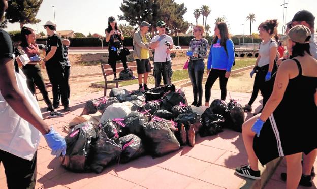 Voluntarios con residuos recogidos ayer en San Javier y que se utilizarán para la escultura. 