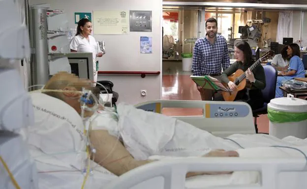 Un paciente de la UCI escucha a Rafael Pascual y Natalia Roda interpretar una canción, este jueves en La Arrixaca. 