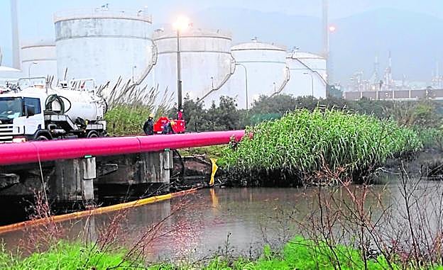 Operarios observan los trabajos de extracción del vertido. 