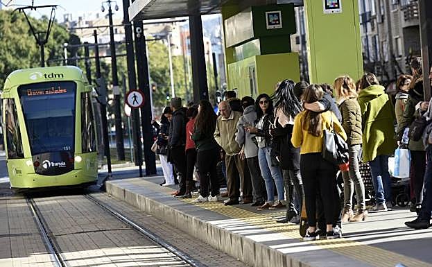 Vecinos de Murcia esperan la llegada del tranvía en una parada de la ciudad. 