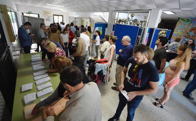 Un grupo de votantes elige su papeleta, este domingo, en un colegio electoral de la Región.