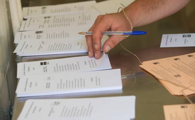 Un votante recoge las papeletas para votar este domingo.