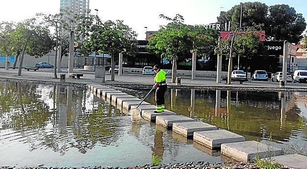 Un operario limpia las aguas del lago junto a las Atalayas.