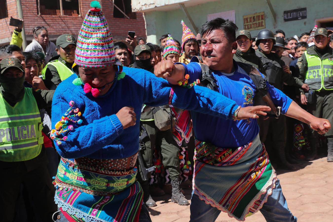 Indígenas bolivianos de Potosí festejan durante la tradicional fiesta de la Cruz en San Pedro de Macha (Bolivia). Puñetazo a puñetazo, unas gotas de sangre riegan la Pachamama, la Madre Tierra, en una de las tradiciones milenarias más singulares de Bolivia, el tinku o encuentro de Macha. 