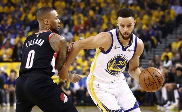 Stephen Curry dribla a Damian Lillard.