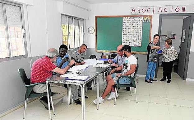 Dos voluntarios dan clases de español a tres usuarios de la Asociación Neri, que preside Pepita Esparza. 