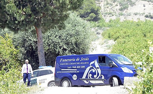 Un vehículo de la Guardia Civil y otro del servicio funerario acuden al lugar del accidente.