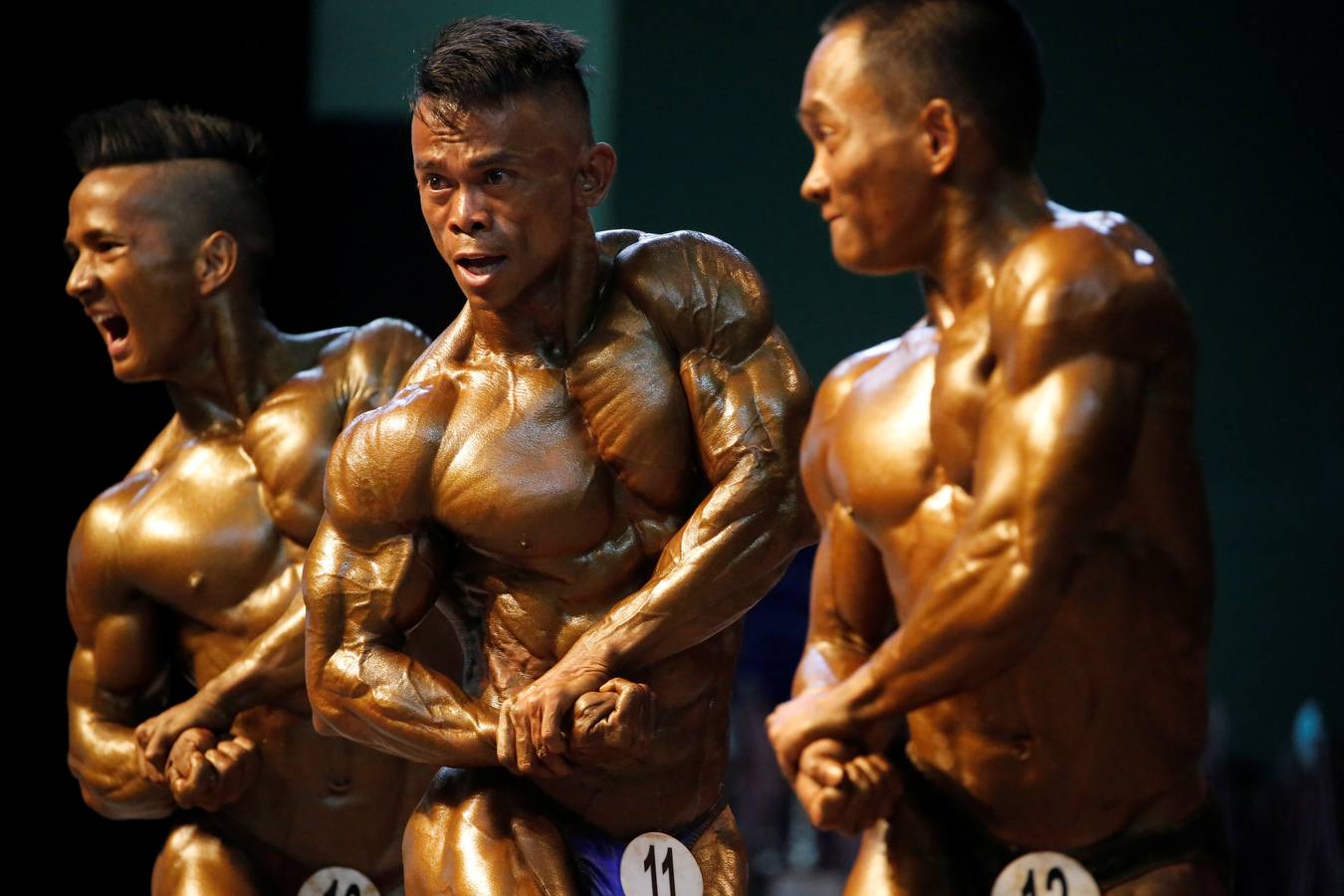 Los participantes exhiben sus bronceados y perfectamente tonificados músculos durante la 16 edición del campeonato de Culturismo y Deportes del Sudeste Asiático celebrado en Yangon (Birmania).