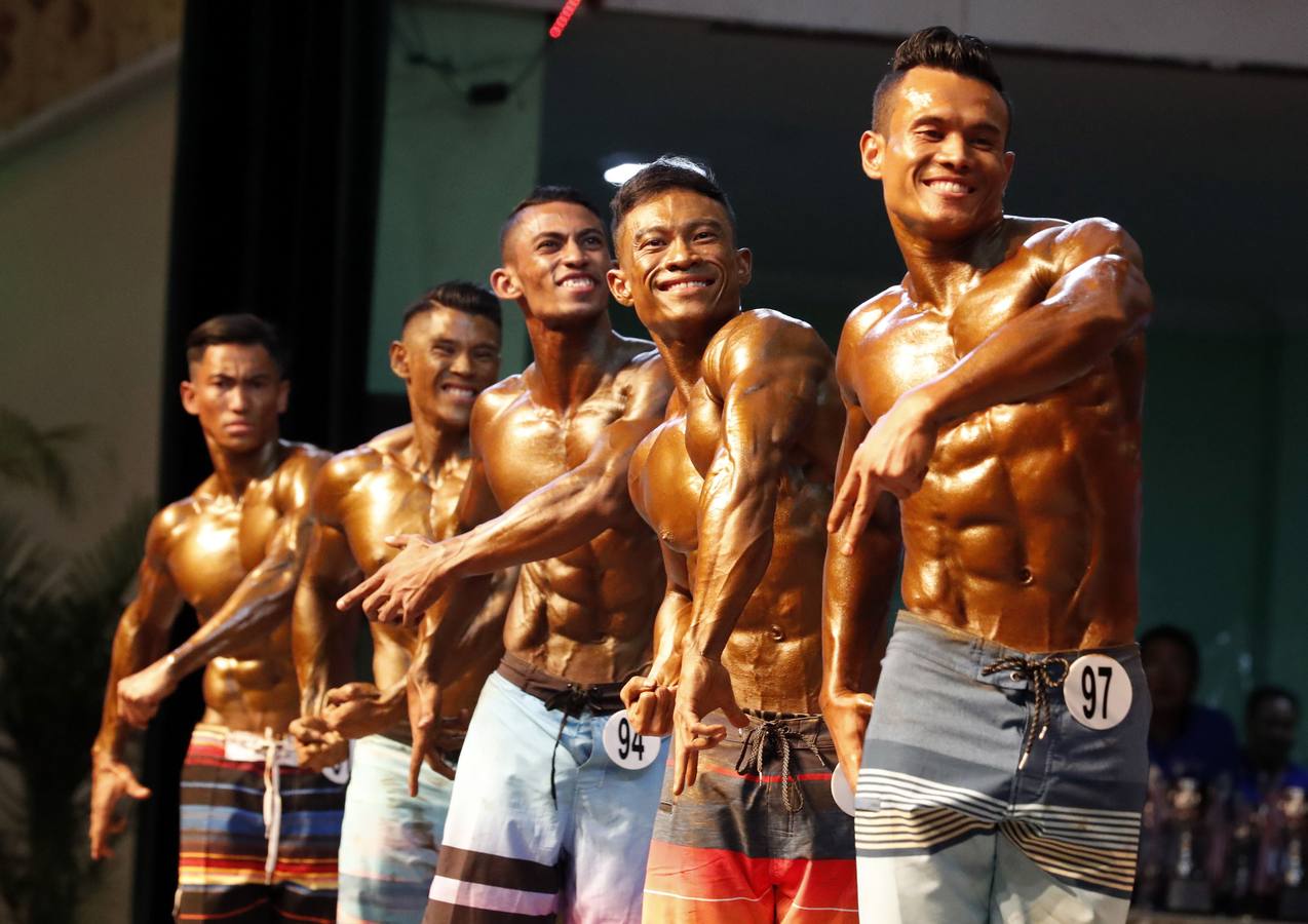 Los participantes exhiben sus bronceados y perfectamente tonificados músculos durante la 16 edición del campeonato de Culturismo y Deportes del Sudeste Asiático celebrado en Yangon (Birmania).