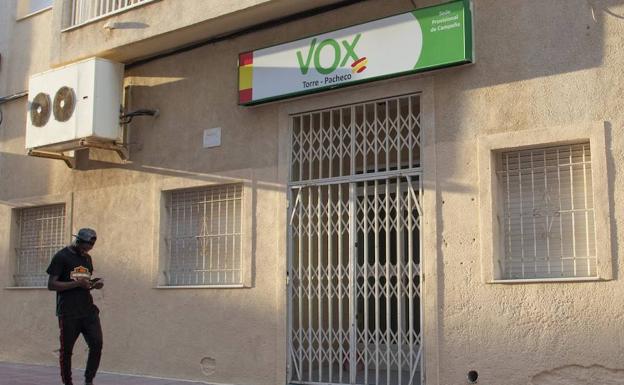 Un inmigrante pasa por delante de la sede de Vox en el municipio de Torre Pacheco.