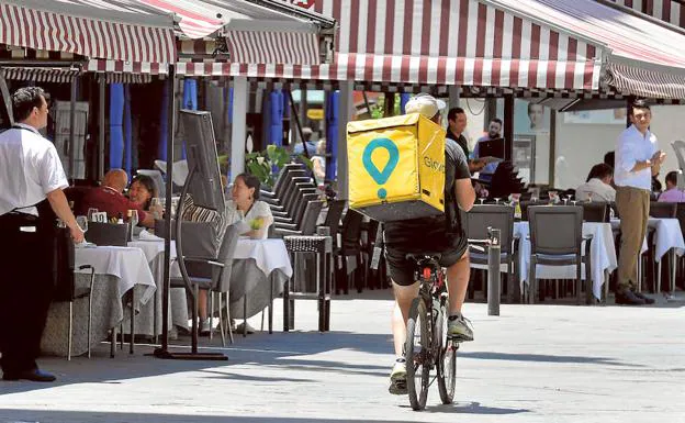 Un repartidor de Glovo circula en bicicleta por la plaza de Santa Catalina de Murcia.