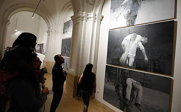 Algunos visitantes observan una obra de la exposición 'Siete', de Pedro Cano.