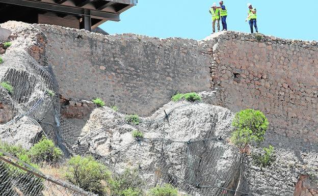 Técnicos revisan desde la muralla del castillo la colocación de las mallas de seguridad . 