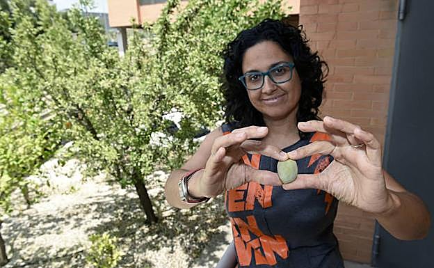 La investigadora Raquel Sánchez-Pérez sostiene una almendra.